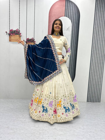 Woman wearing an off-white lehenga choli with elephant embroidery and a navy blue dupatta.