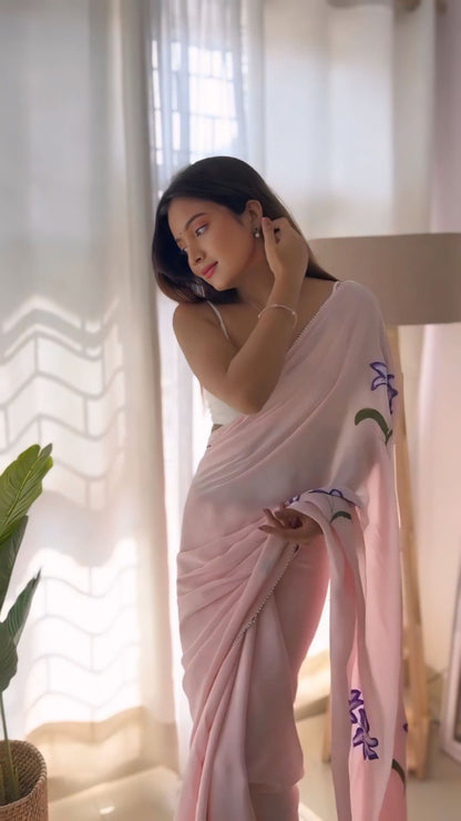 Stylish woman in a pink floral georgette ready-to-wear saree indoors.