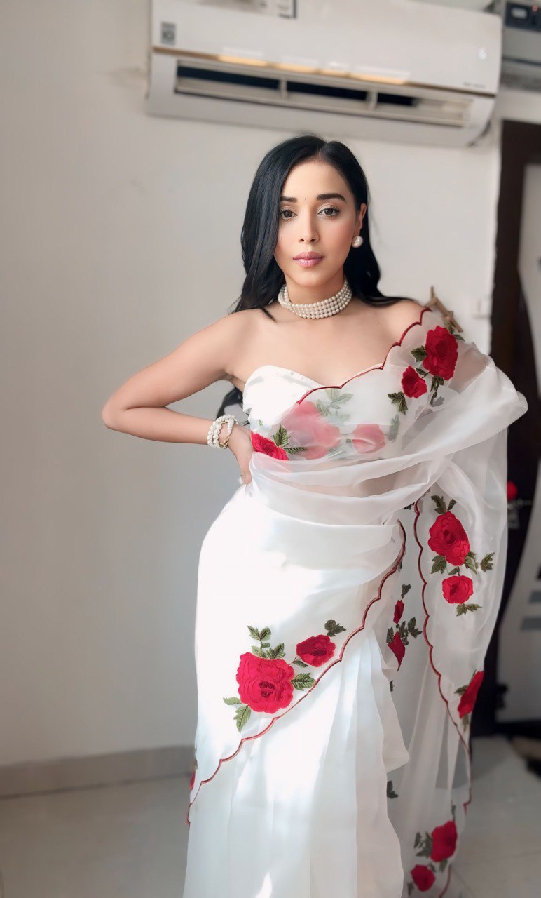 Elegant woman in white organza saree with romantic red rose prints.