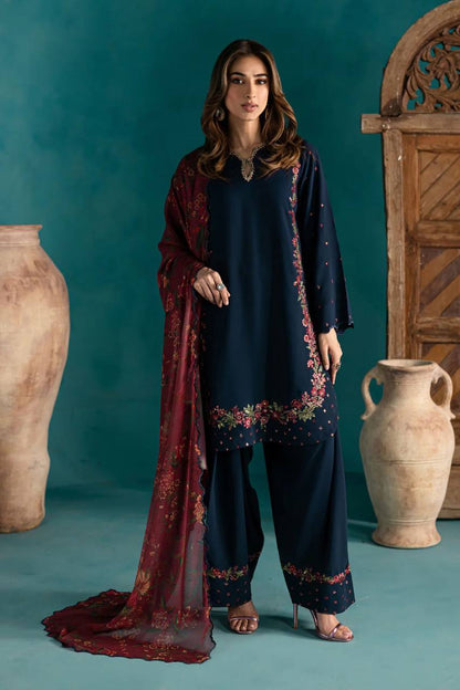 Woman wearing navy blue embroidered Farsi party set with maroon floral dupatta, standing elegantly.