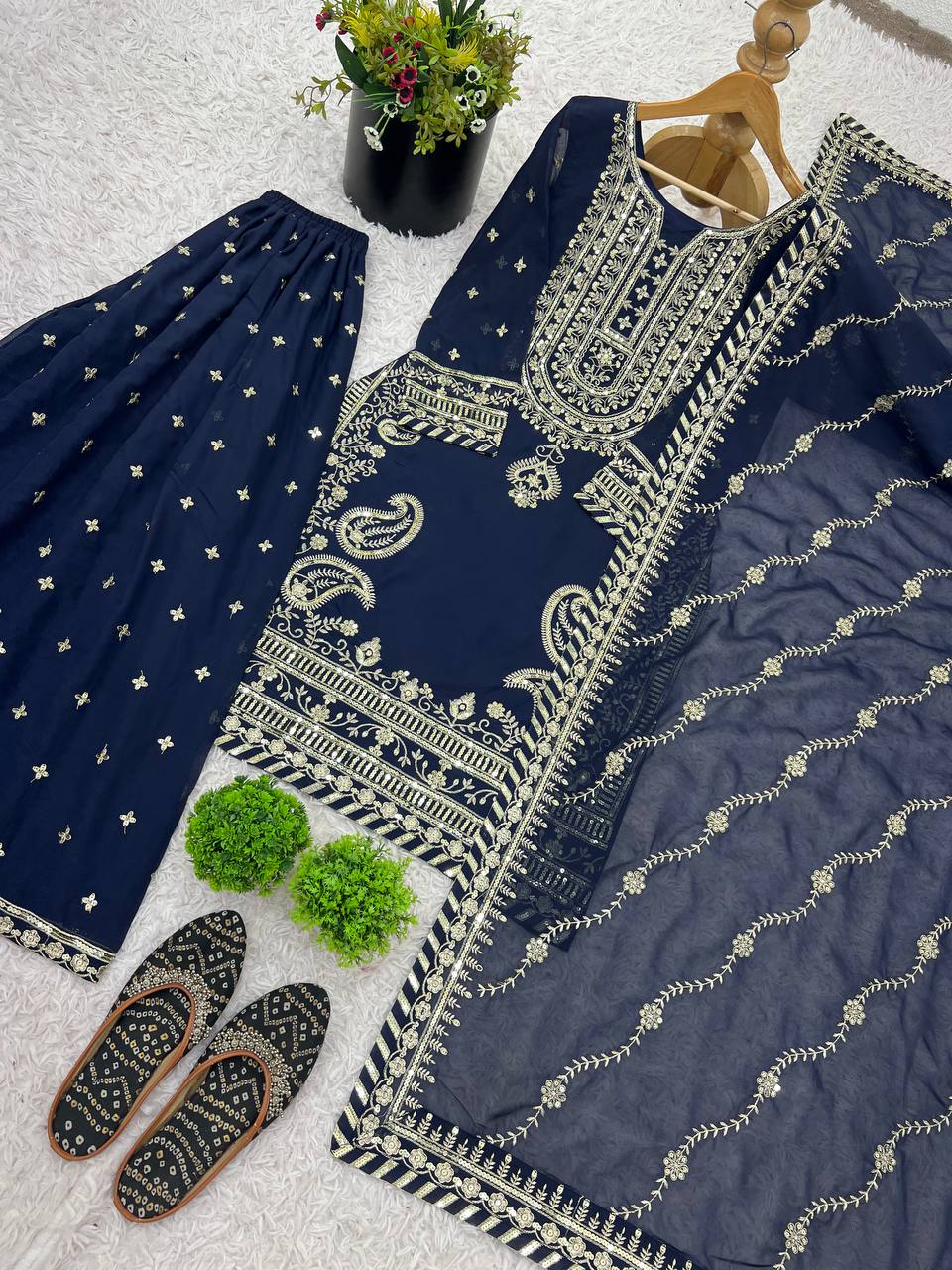 Sharara set with navy blue embroidered kurta, matching bottoms, and sheer dupatta, styled with juttis.