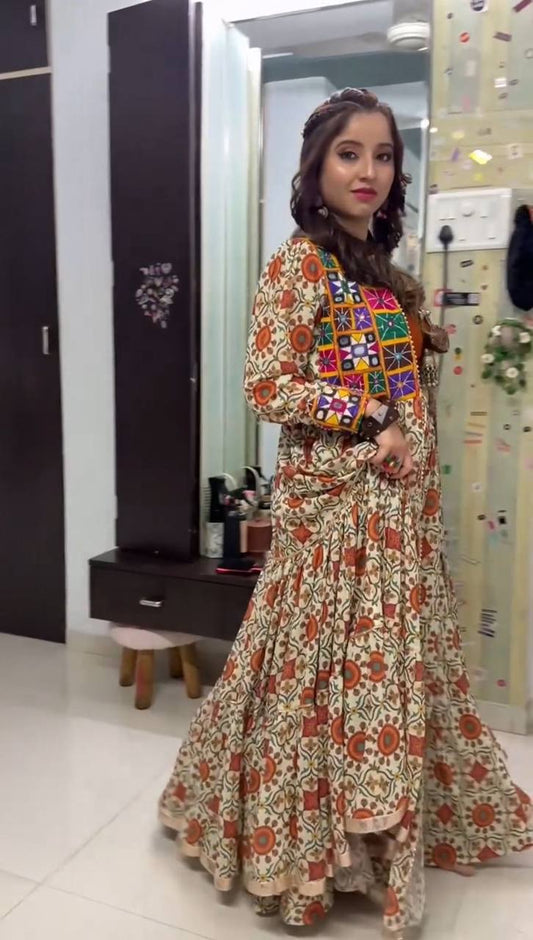 Woman wearing Kachchi Charm festive lehenga choli set with vibrant mirror work shrug and floral embroidery.