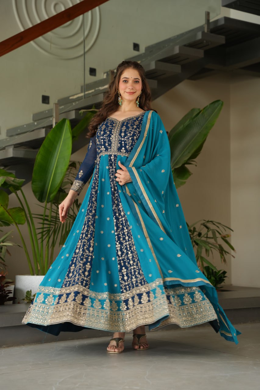 Woman in a vibrant blue and gold zari embroidered gown and dupatta.