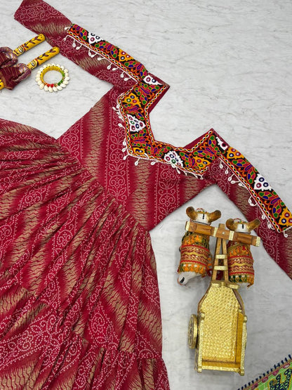 Close-up of red Bandhni gown's embroidered neckline, with dandiya sticks and traditional decor.