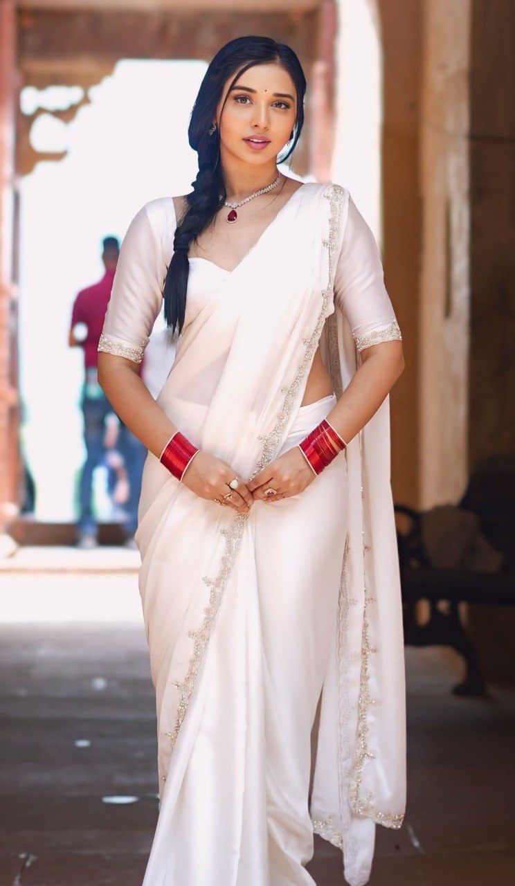 Model wearing white Rangoli Silk Ready To Wear Saree with red bangles and matching jewelry.