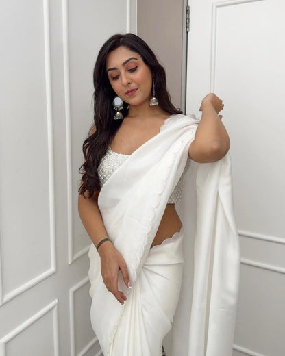Model in pristine white Rangoli silk saree featuring delicate scalloped edge detailing.