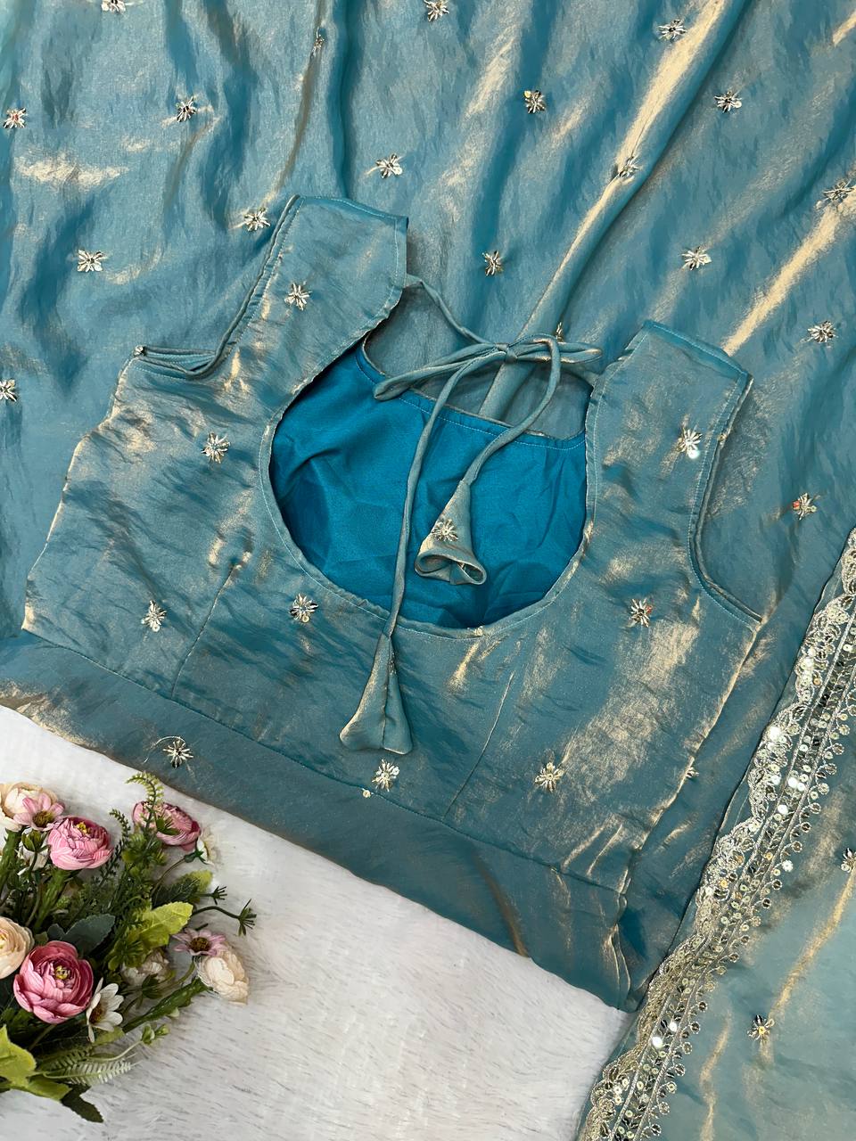 Close-up of teal gown with embroidery and tie back.