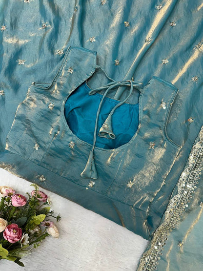 Close-up of teal gown with embroidery and tie back.