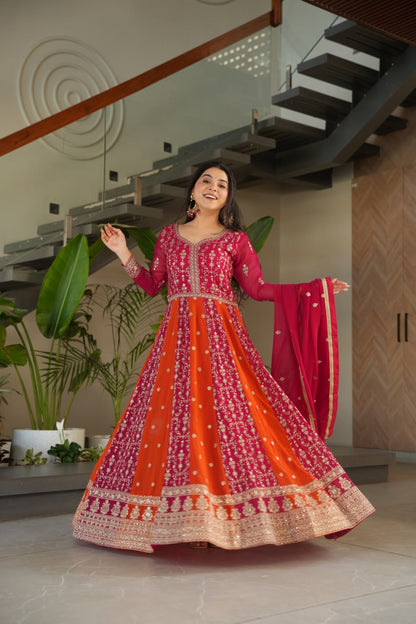 Woman in vibrant pink and orange zari embroidered gown and dupatta.