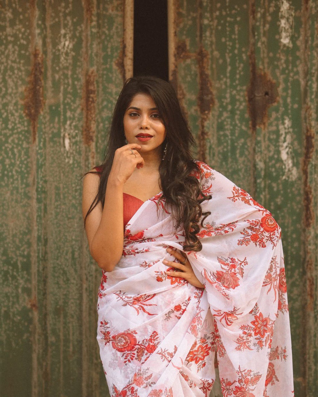 Woman poses in a stylish off-white and red floral georgette saree, ready-to-wear.