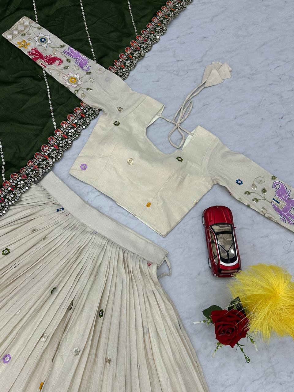 Overhead close-up of the embroidered choli of the off-white lehenga.