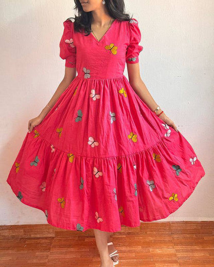 Front view of a woman in a pink Butterfly Maxi Dress with a flared skirt.
