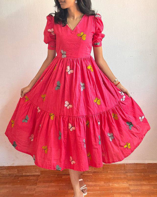 Front view of a woman in a pink Butterfly Maxi Dress with a flared skirt.