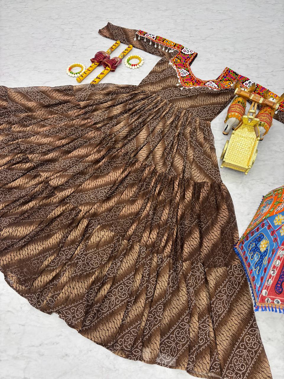 Full brown Bandhni print gown displayed flat, highlighting festive embroidery and accessories.