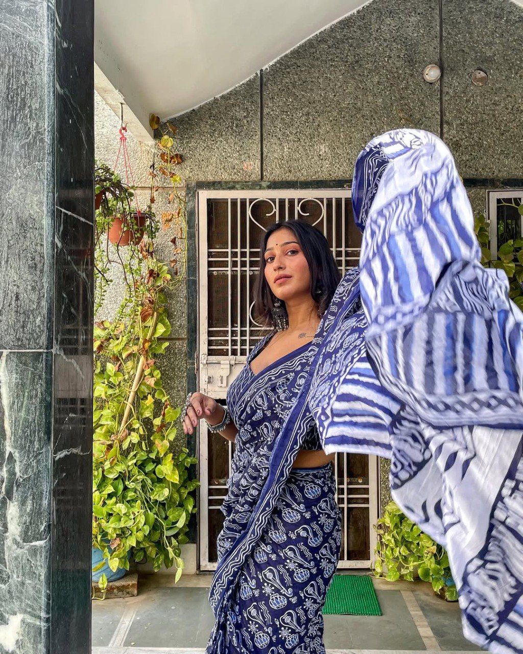 Close-up of woman in comfortable blue and white cotton saree, ready to wear.