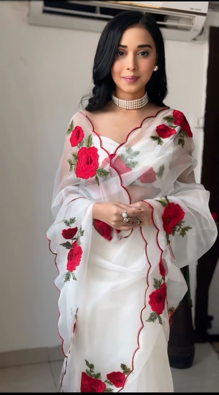 Detailed view of the red rose embroidery on the elegant white saree.