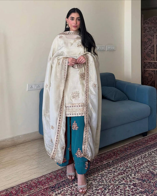 Woman wearing Rangbhoomi Silk Splendor Party Wear in cream and teal with embroidery.