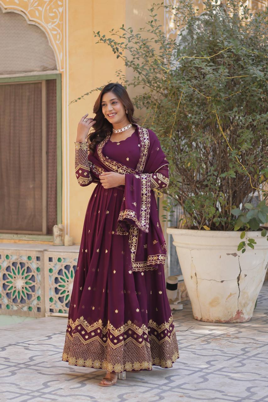 Model in a plum Anarkali dress with intricate embroidery and a flowing dupatta.