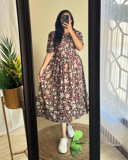 Woman wearing Kalamkari print cotton maxi dress in mirror selfie.