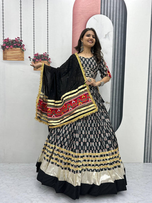 Model twirling in black and gold lehenga choli with ribbon work and statement dupatta for festive celebrations.