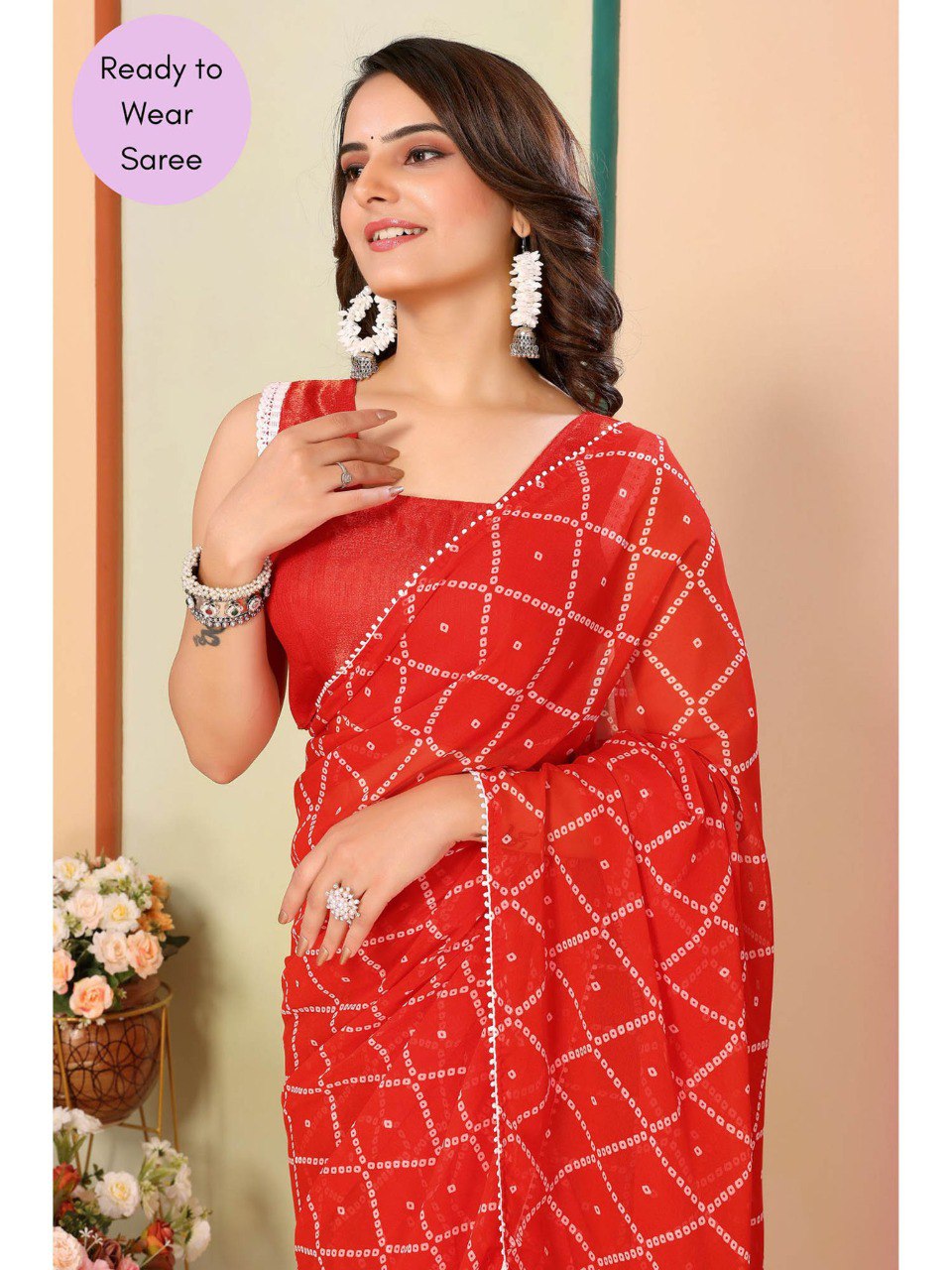 Close-up of vibrant orange ready to wear saree featuring a delicate white lace border.