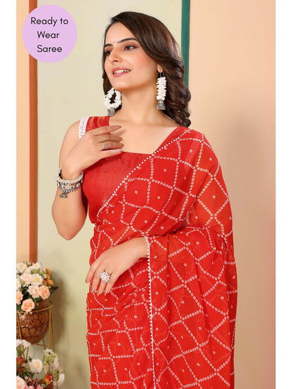 Close-up of vibrant orange ready to wear saree featuring a delicate white lace border.
