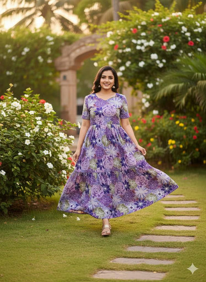 Woman in a flowing purple floral maxi dress, tiered design.