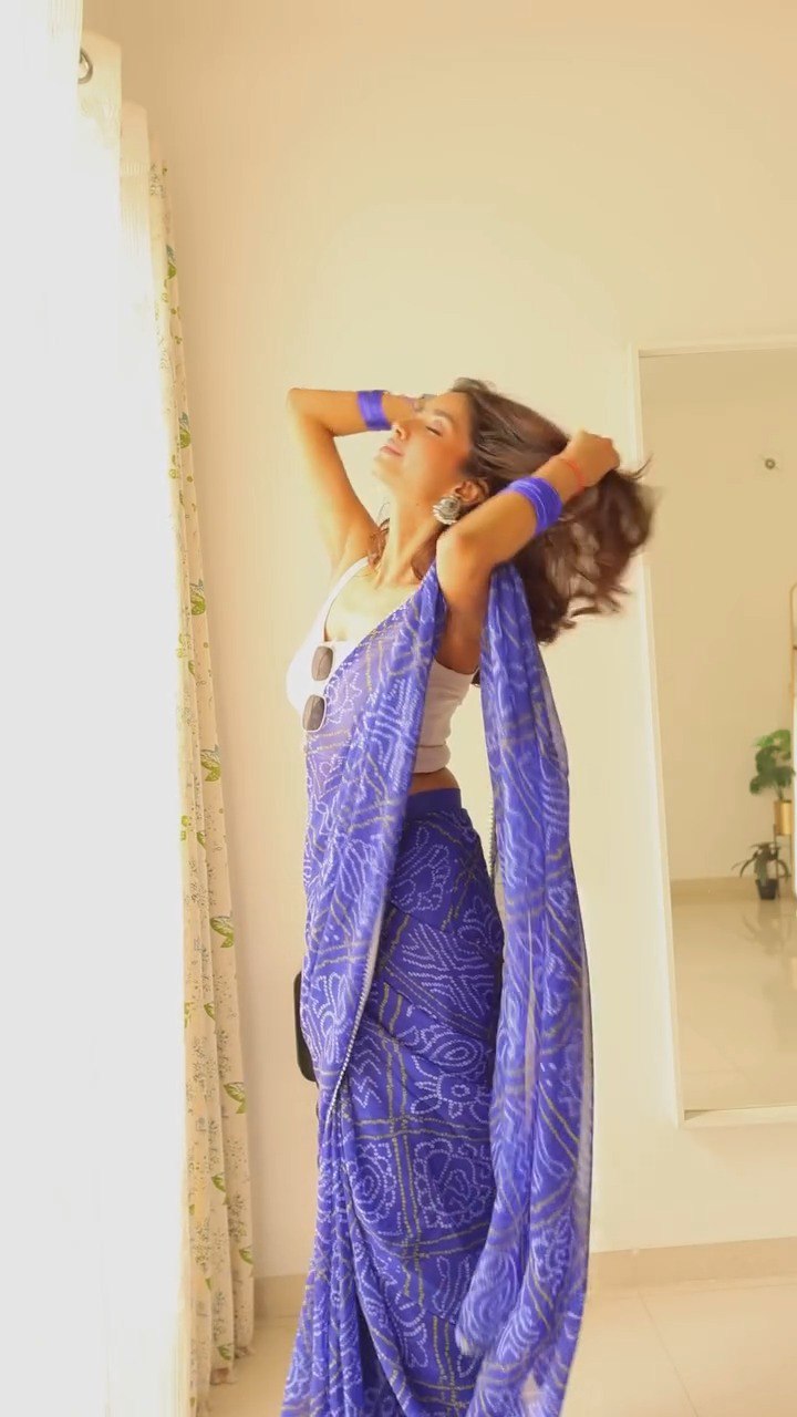 Model in flowing blue georgette saree, enjoying the light and airy fabric.