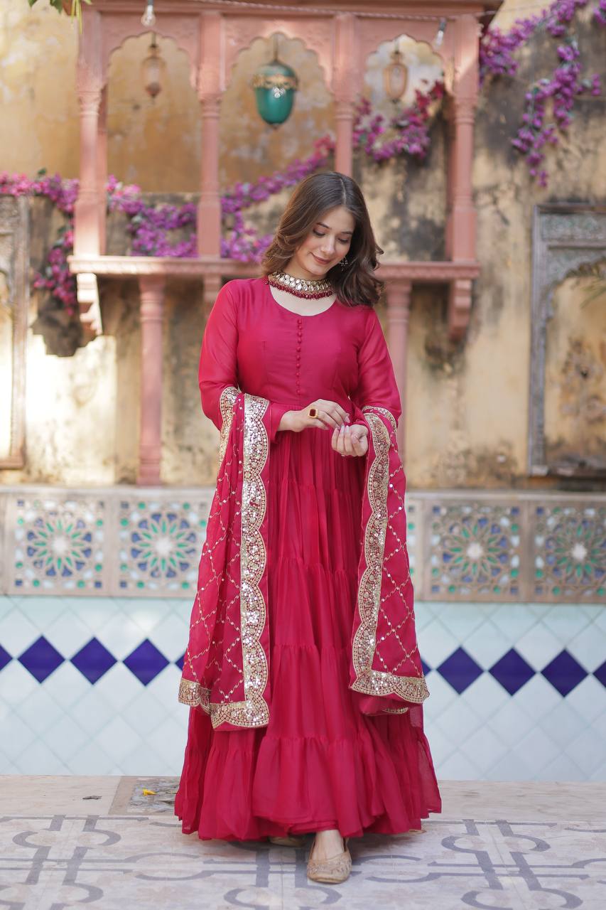 Woman wearing a red flared gown with embroidered dupatta, hand on her ring.