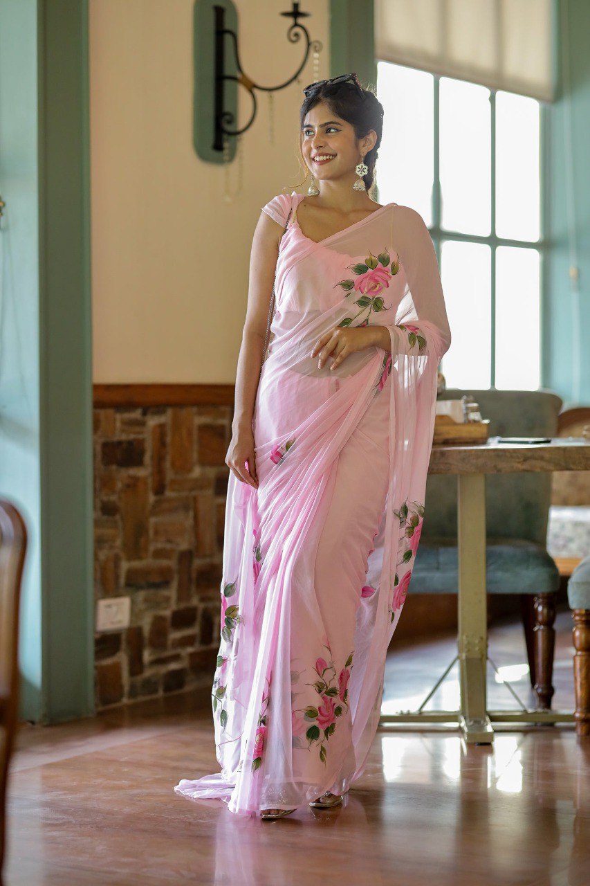 Woman in elegant pink georgette rose saree smiling in sunlight.