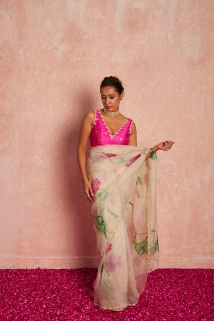 Close-up of scalloped border and golden trim on the pink organza saree.