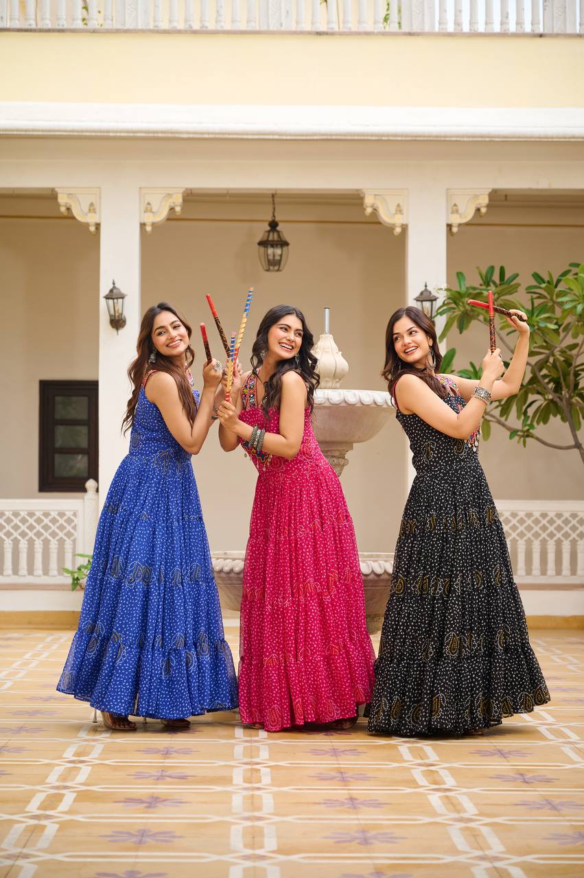Three women in blue, pink, and black Bandhani Gamathi gowns, ready for Navratri Garba.