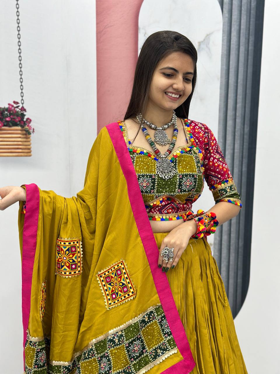 Mustard yellow lehenga choli set with detailed dupatta, laid flat with jewelry and bangles.