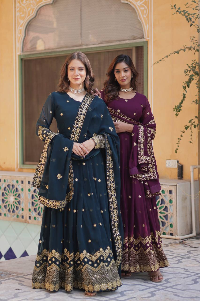 Two models wearing plum and teal Anarkali gowns with gold embroidery.