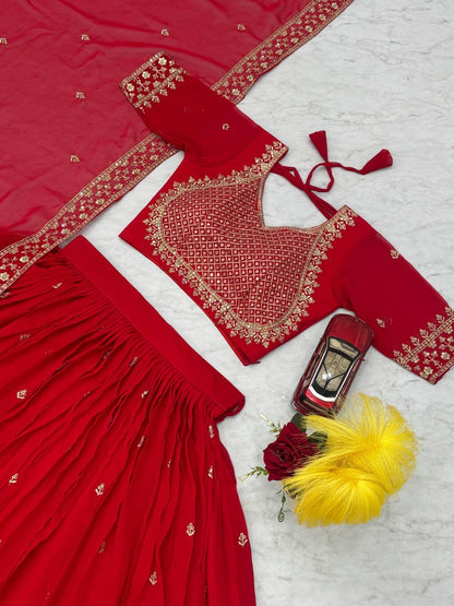Close up of red choli, lehenga, and dupatta with gold embroidery.