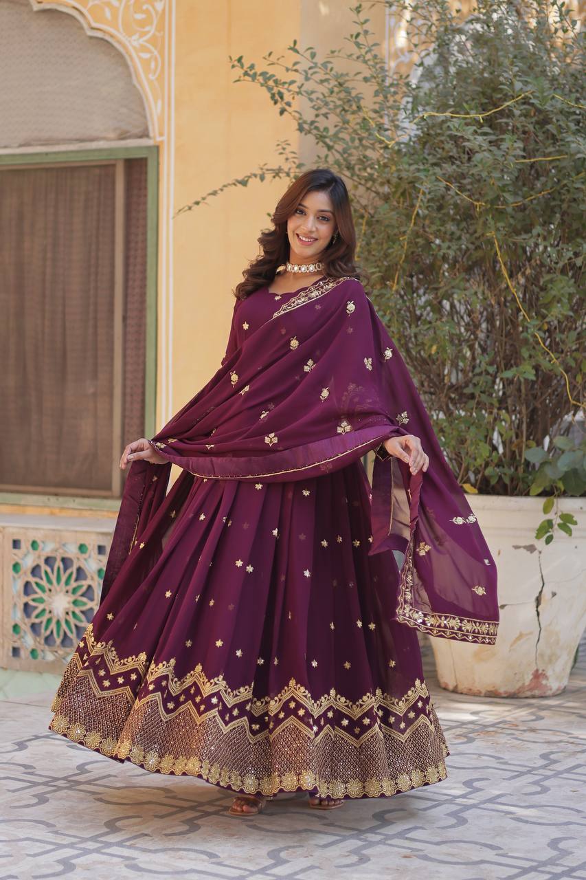 Woman wearing a plum embroidered Anarkali gown with matching dupatta.
