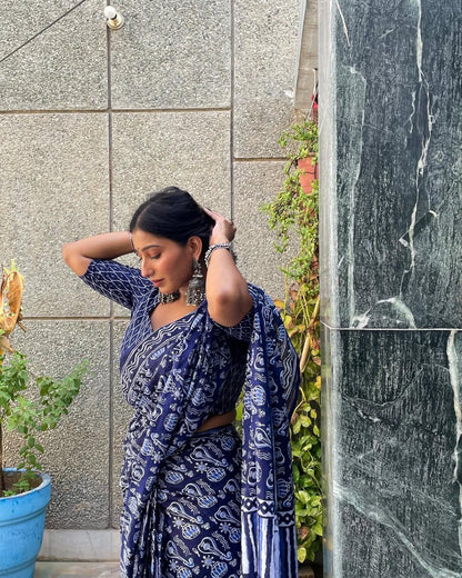 Side view of woman in elegant blue and white cotton saree with jewelry.