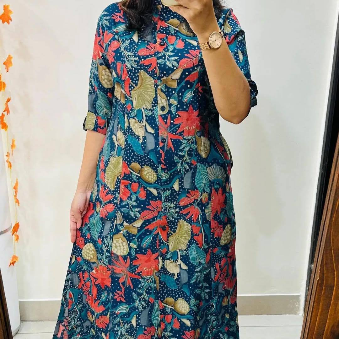 Woman wearing Blue Forest Kurti Set with vibrant floral print and rolled-up sleeves.