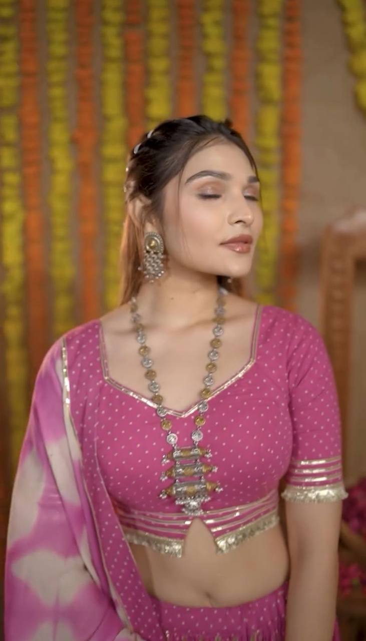 Close-up of the pink polka dot choli with sweetheart neckline and statement oxidized necklace, festive attire.