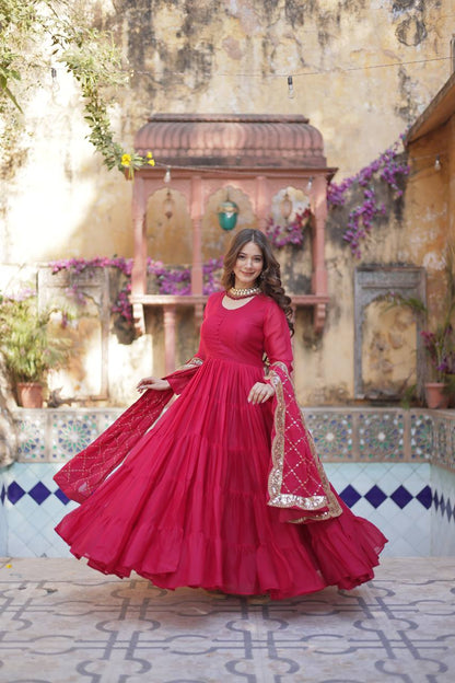 Woman in a red flared gown with embroidered dupatta, showing the gown's detail.