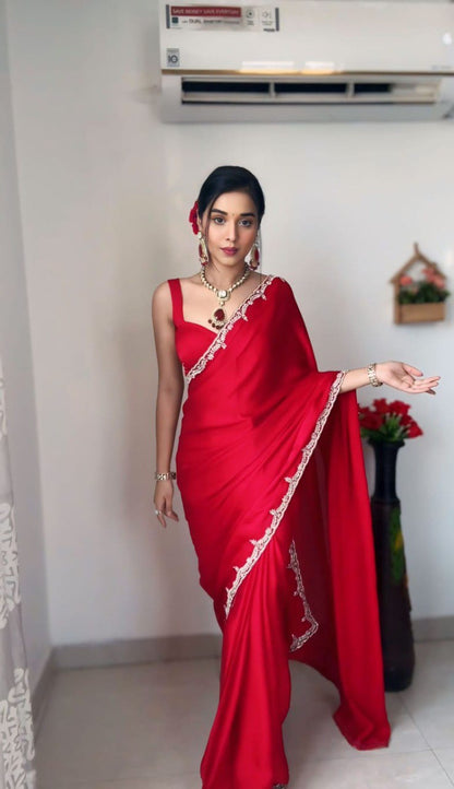 Woman in a red Rangoli Silk Ready To Wear Saree with embellished border and jewelry set.