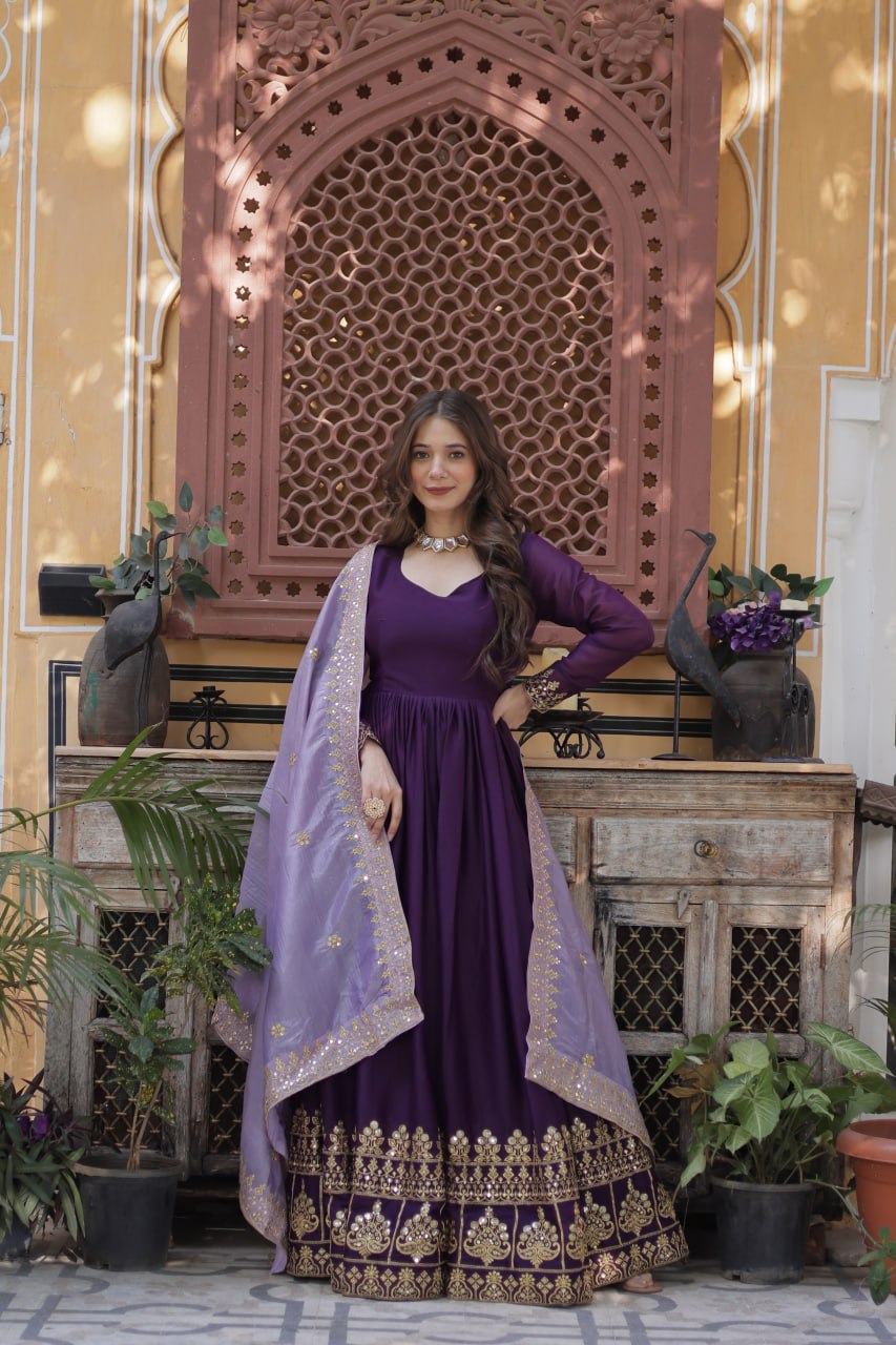 Woman in a purple gown with intricate gold embroidery and dupatta.