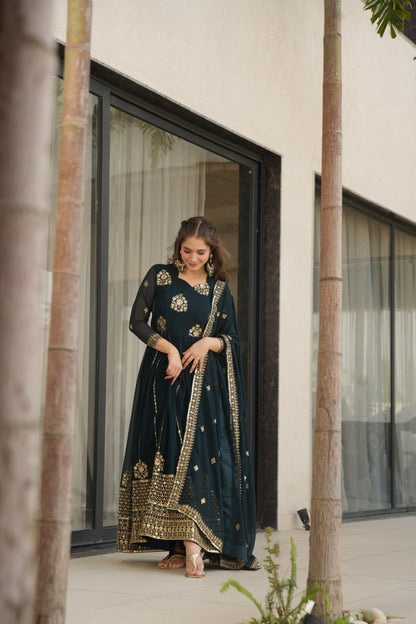 Woman in a Rama green designer gown and dupatta, elegant pose.