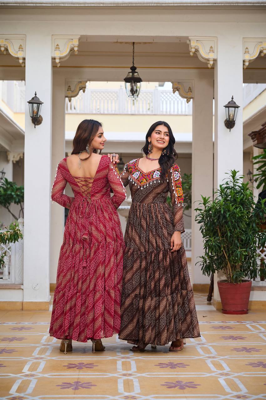 Back view of red and brown Bandhni Gamathi gowns, showing lace-up detailing and vibrant embroidery.