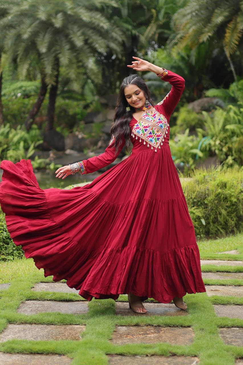 Maroon Kutchi embroidered gown with layered skirt, captured mid-twirl for a festive Navratri look.