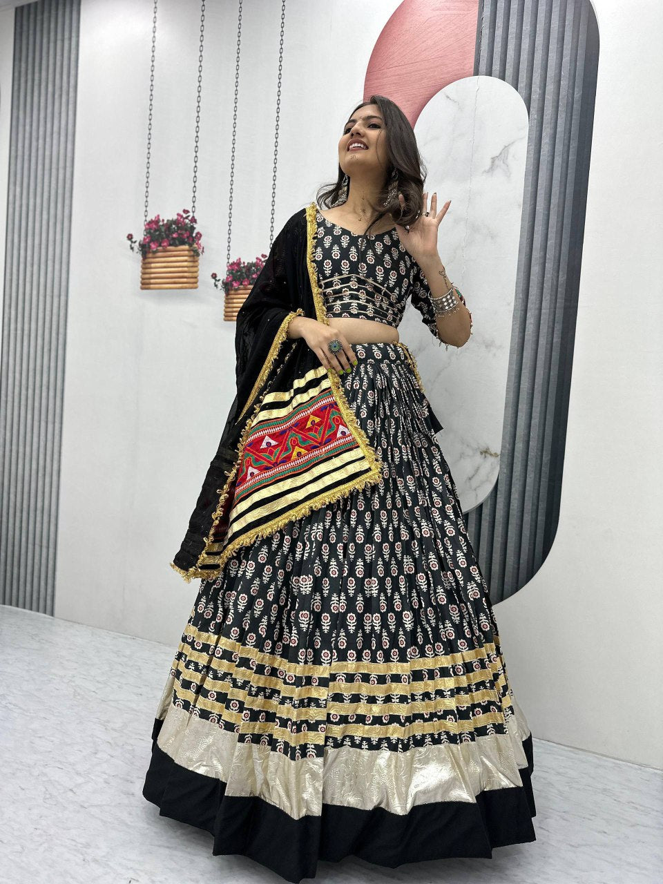 Elegant black lehenga choli with gold accents and embroidered dupatta, styled for Navratri or dance events.