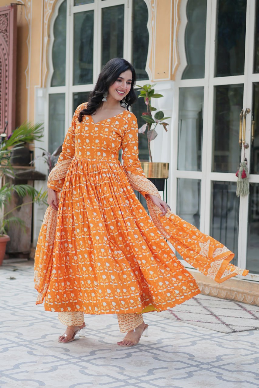 Model in orange floral pure cotton kurti set, posing gracefully with light, airy dupatta.