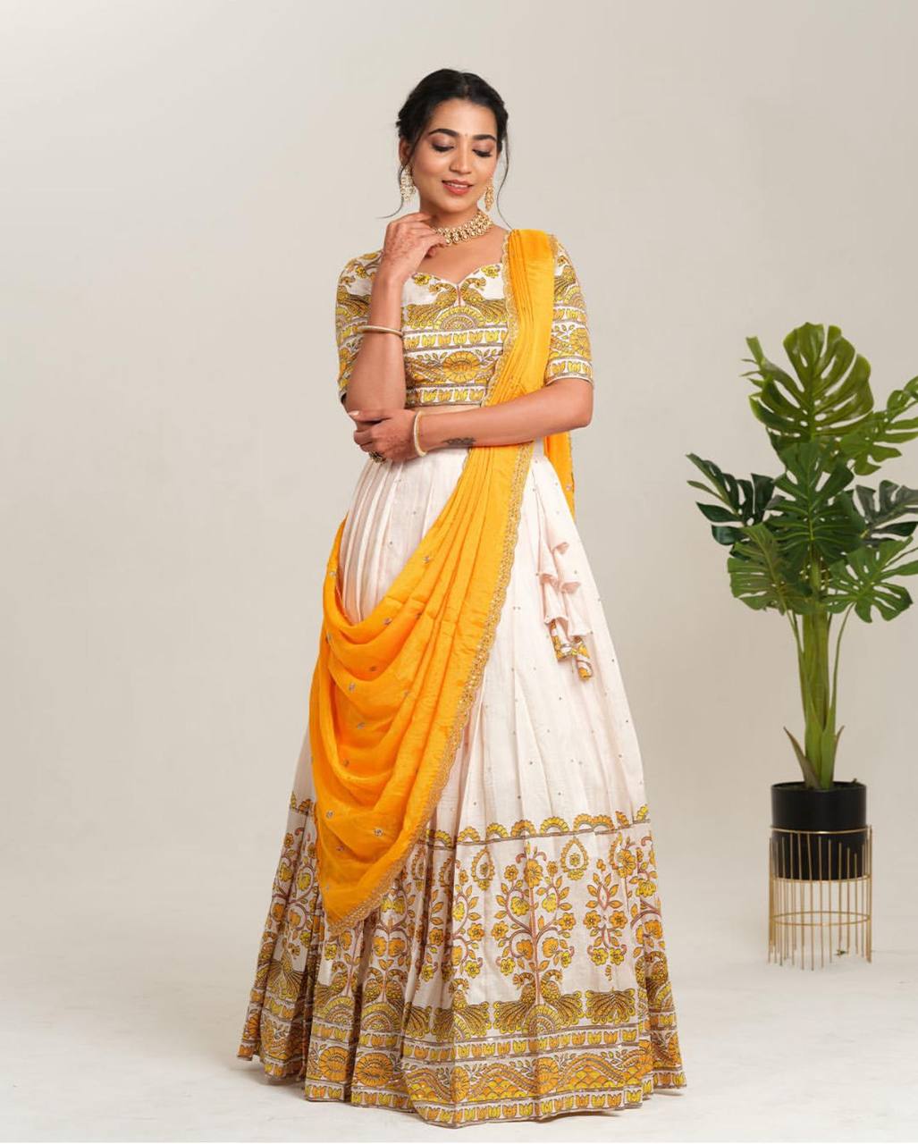 Full view of Kalamkari lehenga choli set in white and yellow.