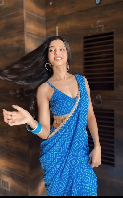 Woman wearing a blue ready to wear georgette saree with a geometric print and gold trim.