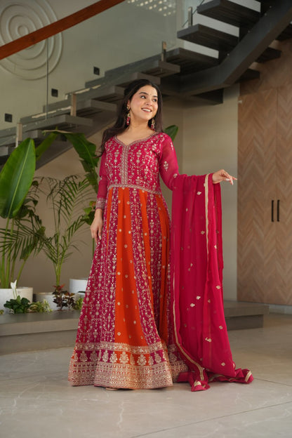 Woman posing in a pink and orange zari embroidered gown with dupatta.